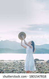 Asian Chinese young female girl in white one piece dress with hat. Blue sky summer outdoor airy breeze