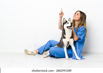 Tierarzt mit sibirischem Husky-Hund, der auf dem Boden sitzt und mit dem Zeigefinger zeigt, eine großartige Idee