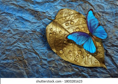 Daun emas dalam tetesan air dan kupu-kupu morfo tropis cerah dengan latar belakang cat air biru