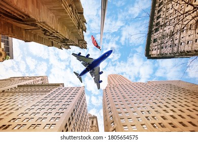 Plane over sky between skyscraper buildings and USA American flag in New York
