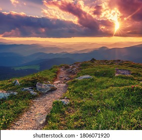 Verbazingwekkend berglandschap met kleurrijke levendige zonsondergang op de bewolkte hemel en pad door de rotsen, natuurlijke buitenreisachtergrond. Schoonheid wereld.
