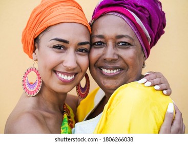 Porträt einer glücklichen afrikanischen Mutter und Tochter von Angesicht zu Angesicht, während sie sich umarmen - Familie, Mutter und erwachsenes Kind lieben - Frauen mit traditioneller Kleidung