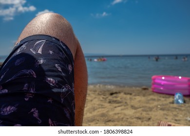 Mann, der am Strand ein Sonnenbad nimmt und Menschen auf See beobachtet, Mini-Pool im Sand, Schildkröte, Krabbe, Seepferdchen, Delphin und Segelbot-Bild auf See kurz