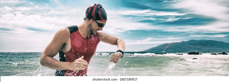 Triathlon competition swimmer man swimming looking at heart rate monitor tracker smartwatch. Panoramic banner. Outdoor sports.