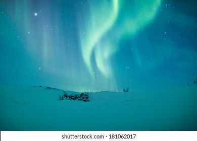 Nordlichter (Aurora borealis) über einem schneebedeckten Berg in Schweden