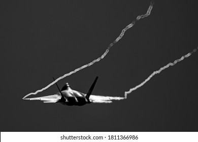 航空ショーのデモンストレーション中に、戦闘機の翼端から水蒸気がたなびきます。