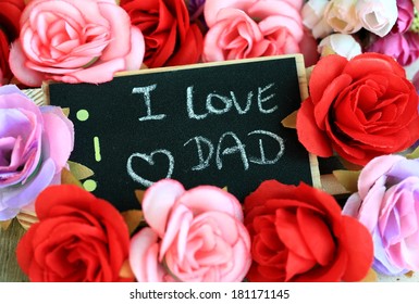 Nachricht von "I love dad" mit Rosen im Hintergrund, Zeichen für den Vatertag