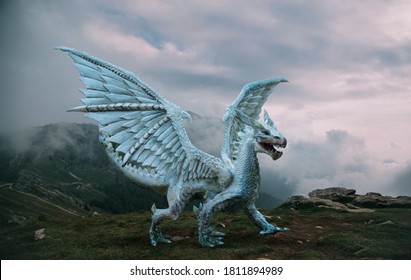 Fantasy-Drache steht auf der Spitze des Berges. Ein riesiges gefährliches Tier mit großen, scharfen Flügeln. Schöner alpiner Naturhintergrund, dramatischer grauer blauer Himmel mit weißen Wolken.
