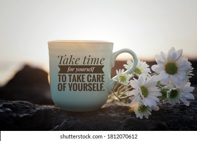 Self love inspirational motivational words - Take time for yourself to take care of yourself. Cup of morning tea or coffee with flowers on sea rock in the beach on background of sunset sunrise light.
