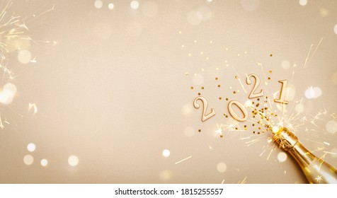 金色のシャンパンボトル、紙吹雪の星、2021年の数字を使ったクリエイティブなクリスマスと新年のグリーティングカード。フラットレイ。バナー形式。