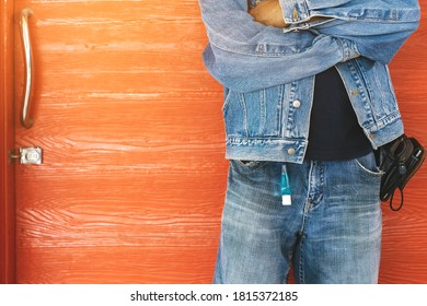 板の背景を持つ男性のジーンズのベルトループにぶら下がっているコロナウイルス(Covid-19)を殺すミニポータブルアルコールジェルボトル. ニューノーマルなライフスタイル。ヘルスケアのコンセプト。アルコールジェルの選択と集中