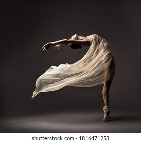 Ballerina dansen met zijde stof, moderne balletdanseres in wapperende zwaaiende doek, Pointe-schoenen, grijze achtergrond