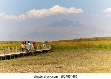 Des gens se promènent sur le pont en bois dans les roseaux et le mont Erciyes. Parc national Sultan Reedy (Sultan Marshes - Sultan Sazligi dans la ville de Kayseri)