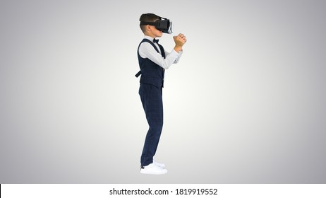 Cậu bé mặc trang phục chỉnh tề chơi trò chơi kiếm trong gog thực tế ảo