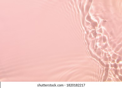Primer plano de la textura de la superficie del agua tranquila clara transparente rosa con salpicaduras y burbujas. Fondo de naturaleza de verano abstracto de moda. Ondas de color coral en la luz del sol.