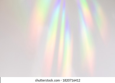 Verschwommener Regenbogen-Lichtbrechungs-Textur-Overlay-Effekt für Fotos und Mockups. Diagonales holografisches Aufflackern des organischen Tropfens auf einer weißen Wand. Schatten für natürliche Lichteffekte