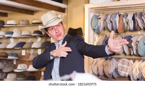 feliz macho adulto español prueba el sombrero occidental en el centro comercial