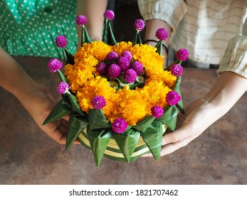 Lễ hội Loy Krathong ở Thái Lan chủ đề phụ nữ tay cầm lá chuối hình hoa sen thân thiện với môi trường hoặc Krathong chứa hoa màu vàng, tím và thân lục bình trên nền mộc mạc.