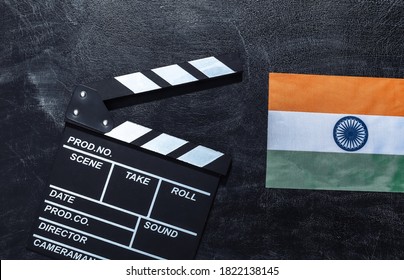 Papan pemukul film dan bendera India di papan tulis kapur. Industri perfilman, hiburan