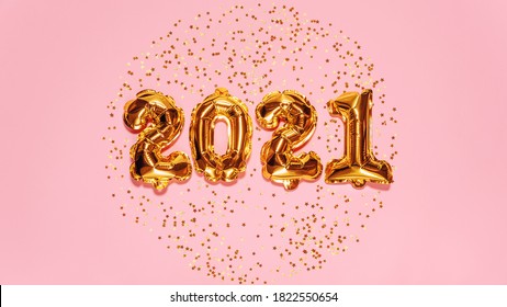 Happy New year 2021 celebration. Bright gold balloons figures, New Year Balloons with glitter stars on pink background. Christmas and new year celebration. Gold foil balloons 2021 gift card