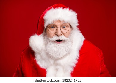 Foto de anciano jubilado barba gris boca abierta mirada emocionada ver criatura mágica de año nuevo hacer deseo traer atmósfera usar traje de santa abrigo gafas sombreros aislado color rojo fondo
