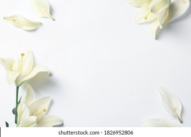 Rahmen aus schönen Lilienblumen auf weißem Hintergrund, flach gelegt. Platz für Text
