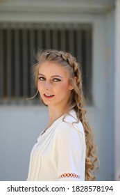 Beautiful Blonde Woman with Braided Long Hair, White Shirt, Barred Window