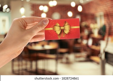 Wanita memegang kartu hadiah di restoran, closeup