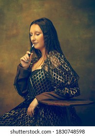 Roken. Jonge vrouw als Mona Lisa, La Gioconda geïsoleerd op donkergroene achtergrond. Retro stijl, vergelijking van tijdperken concept. Prachtig vrouwelijk model als klassiek historisch karakter, ouderwets.