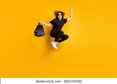 Fuld længde kropsstørrelse portræt af mand, der hopper og råber højt og fejrer stor rabat på sort fredag-udsalg isoleret på lys gul farvebaggrund