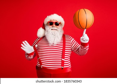 Portrait of his he nice handsome attractive cheerful cheery fat overweight Santa, grandfather spinning ball on forefinger having fun isolated over bright vivid shine vibrant red color background
