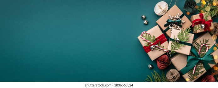Spanduk dengan banyak kotak hadiah diikat pita beludru dan dekorasi kertas dengan latar belakang pirus. Latar belakang Natal.
