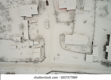 Vista superior del pueblo de invierno con casas y caminos cubiertos de nieve. Vista aérea del paisaje