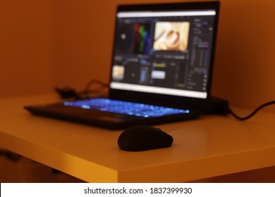 青いキーボードを搭載したゲーミング ノート パソコン。ディスプレイ上の編集プログラム。ブルーボケライト