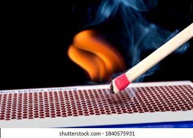 A matchstick lights after it is struck agains the flint surface of a match box.  Everything is real, no flame filters.