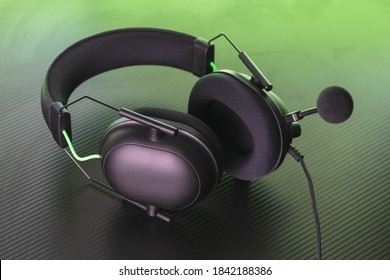 Gaming headset with a microphone attached to it. This headphones feature a green accent