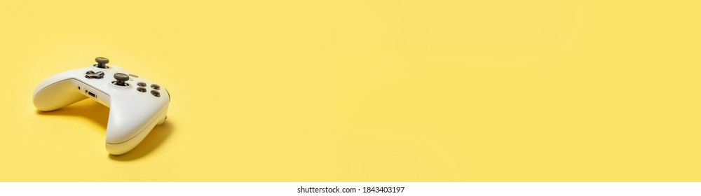 白いジョイスティック ゲームパッド、黄色のカラフルなトレンディな背景に分離されたゲーム コンソール。コンピューター ゲームの競争ビデオゲーム コントロール対立概念。サイバー スペース シンボル バナー