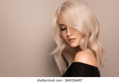 Cô gái xinh đẹp với màu tóc cực kỳ vàng. Kiểu tóc uốn xoăn sành điệu được thực hiện trong một thẩm mỹ viện. Thời trang, mỹ phẩm và trang điểm
