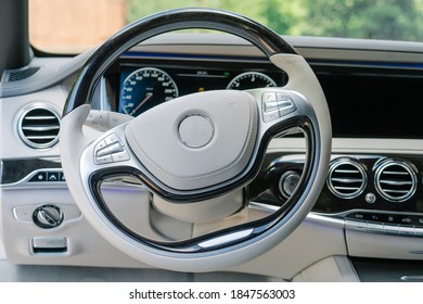Interior de coche moderno en colores claros y dispositivo de navegación.