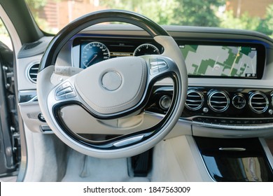 Interior de coche moderno en colores claros y dispositivo de navegación.