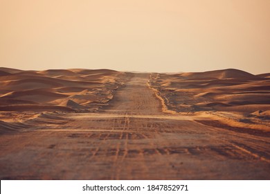 真ん中の砂丘にある空の砂漠の道。アブダビ、アラブ首長国連邦