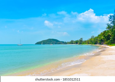 Mooi zandstrand samen met kokos en dennen. Kleine baai met turquoise zee met zeilen onder de blauwe hemel in de zomerochtend. Kustlandschap en Zeegezicht bij Lipa Noi-strand, Samui-eiland, Thailand.