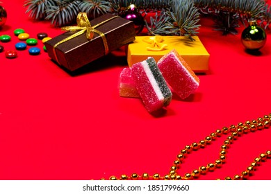 Marmelade gelei en vuren takje met een lint en een stuk speelgoed op een rode achtergrond. Een spandoek op een rode achtergrond voor de zoetwaren