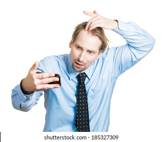 Closeup portrait, shocked man feeling head, surprised he is losing hair, receding hairline or seeing bad news on cellphone, isolated white background. Negative facial expressions, emotion feeling