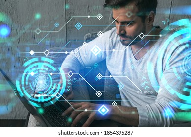 Een serieuze blanke man in vrijetijdskleding, laptop typen om een nieuwe ontwikkelaarscode voor app te maken. Dubbele blootstelling. Informatie koppelt hologram.