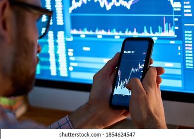 暗号通貨金融株式市場分析に携帯電話アプリ分析を使用するビジネスマントレーダー投資家アナリストは、スマートフォン画面でグラフ取引データインデックス投資成長チャートを分析します。