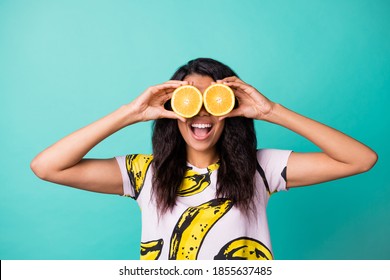 びっくりした浅黒い肌の女の子の写真は、ターコイズ色の背景に分離された目半分スライス オレンジ色の摩耗ピンクの t シャツを隠す