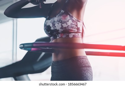 Sporty woman is exercising with Hula hoop in fitness gym for healthy lifestyle concept.