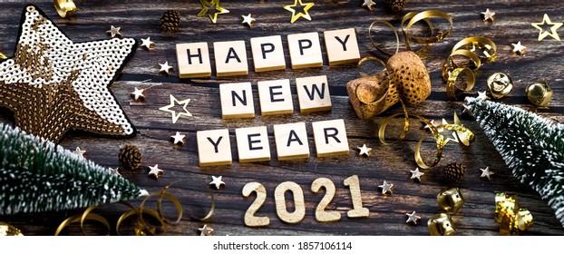 Banner.Happy New Year 2021. Een symbool van het nummer 2021 met gouden ballen, sterren, pailletten en een mooie bokeh op een houten achtergrond. Het concept van de viering.