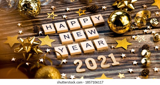 Banner.Happy New Year 2021.木製の背景に金色のボール、星、スパンコール、美しいボケ味が描かれた2021年のシンボル。お祝いのコンセプト。